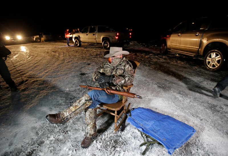 Part of the real-life inspiration for the game: Arizona rancher LaVoy Finicum holds a gun as he guards the Malheur National Wildlife Refuge near Burns, Ore., on Jan. 5, 2016. Ammon Bundy, the leader of a small, armed group occupying the remote national wildlife preserve. (AP Photo/Rick Bowmer, File)